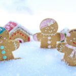 Three gingerbread figures in snow, celebrating a cheerful winter season.